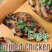 easy grilled chicken on an orange tray with garlic behind.