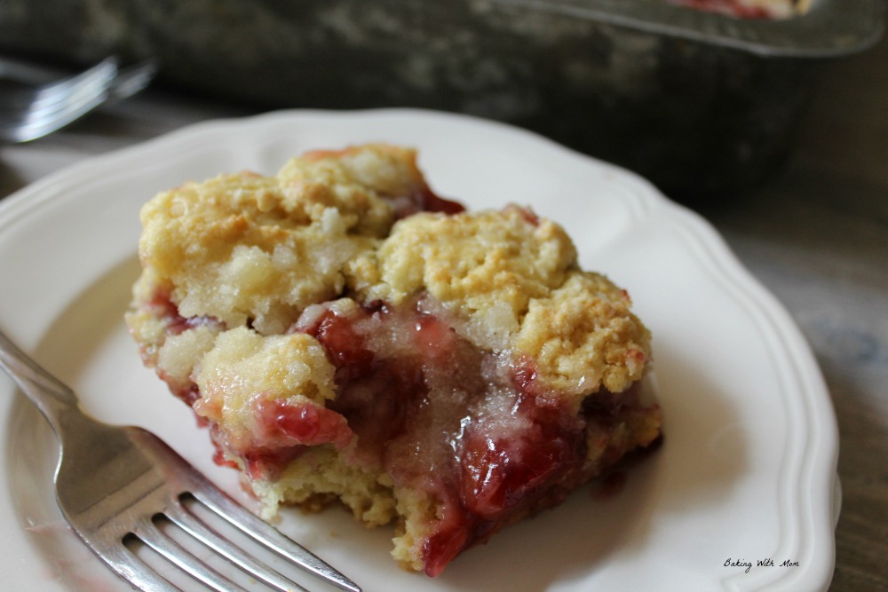 Slice of cherry coffee cake on a white plate with a fork 