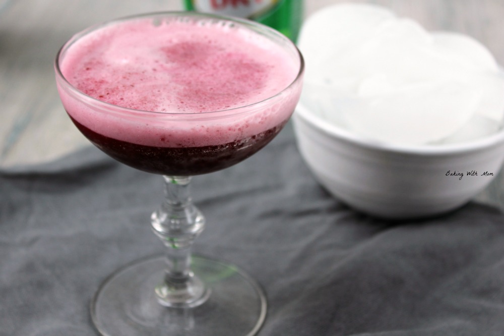 Glass of black cherry drink and a bowl of ice. 