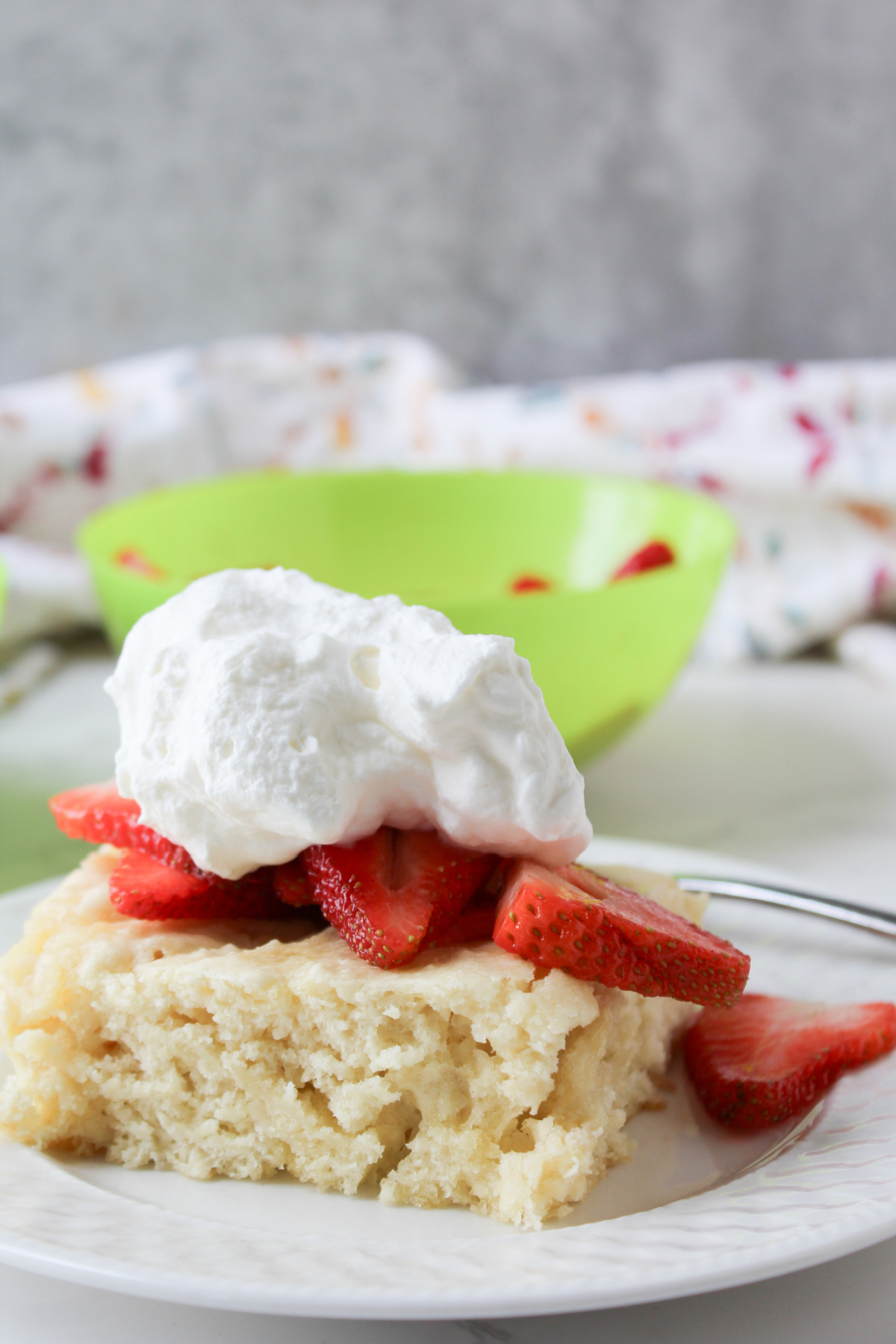 strawberry shortcake with whipping cream on a white plate.