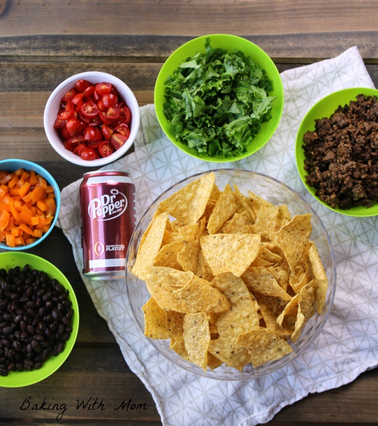 Beans, peppers, tomatoes, lettuce and hamburger in green bowls 