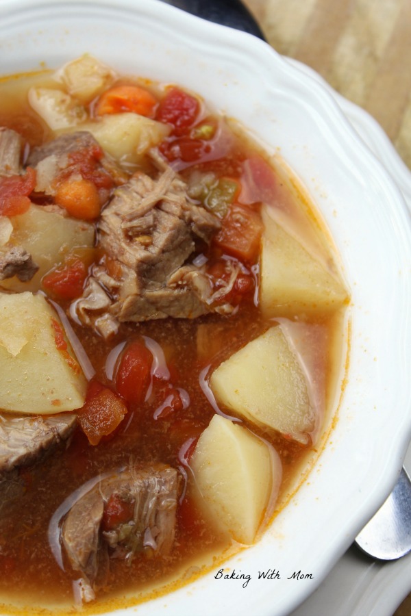 Crock Pot Vegetable Beef Soup in a white bowl with tomatoes, beef and potatoes
