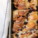 Pull Apart Apple Cinnamon Bread in loaf pan with a white towel laying besides