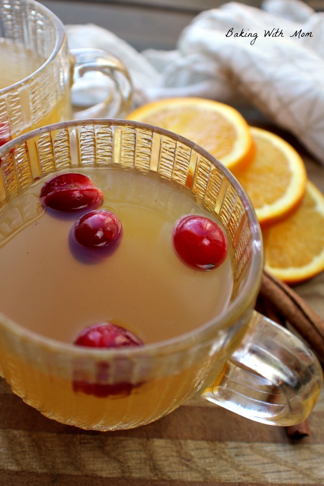 Spiced Apple Cider in clear cups with oranges in background
