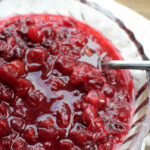 cranberry sauce in a clear bowl with a serving spoon