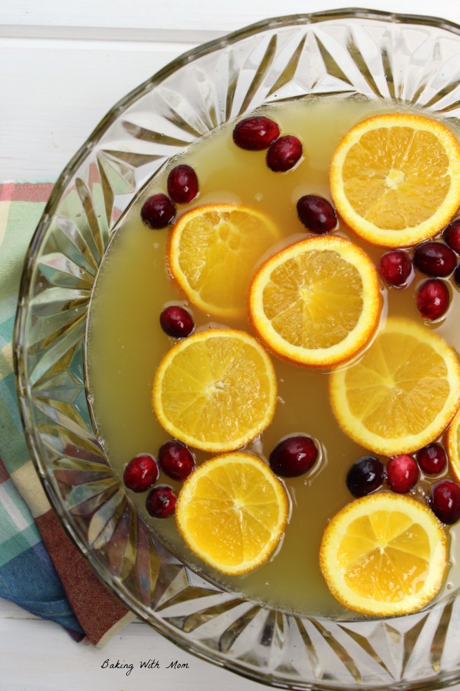 Holiday Orange Juice Punch with orange slices and cranberries in a punch bowl