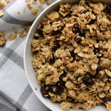 granola in a bowl on a gray and white towel.