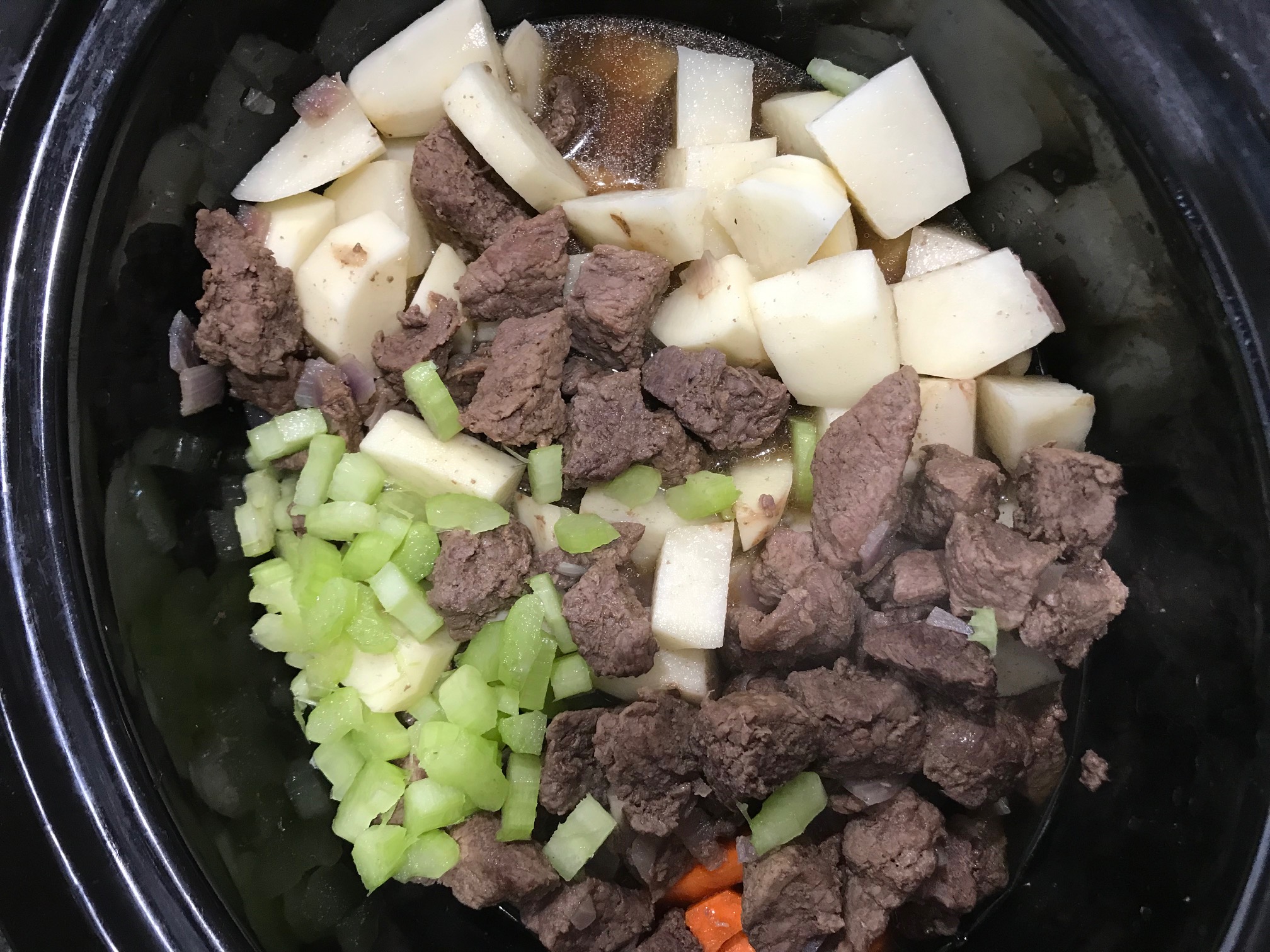 Beef stew meat in crock pot with vegetables
