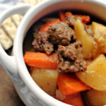 beef stew meat with potatoes and carrots in a bowl.