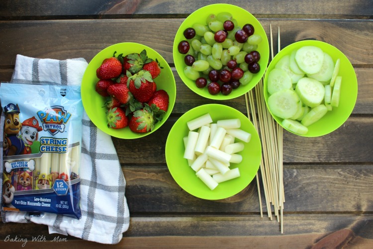 Strawberries, grapes, cucumbers and string cheese in green bowls