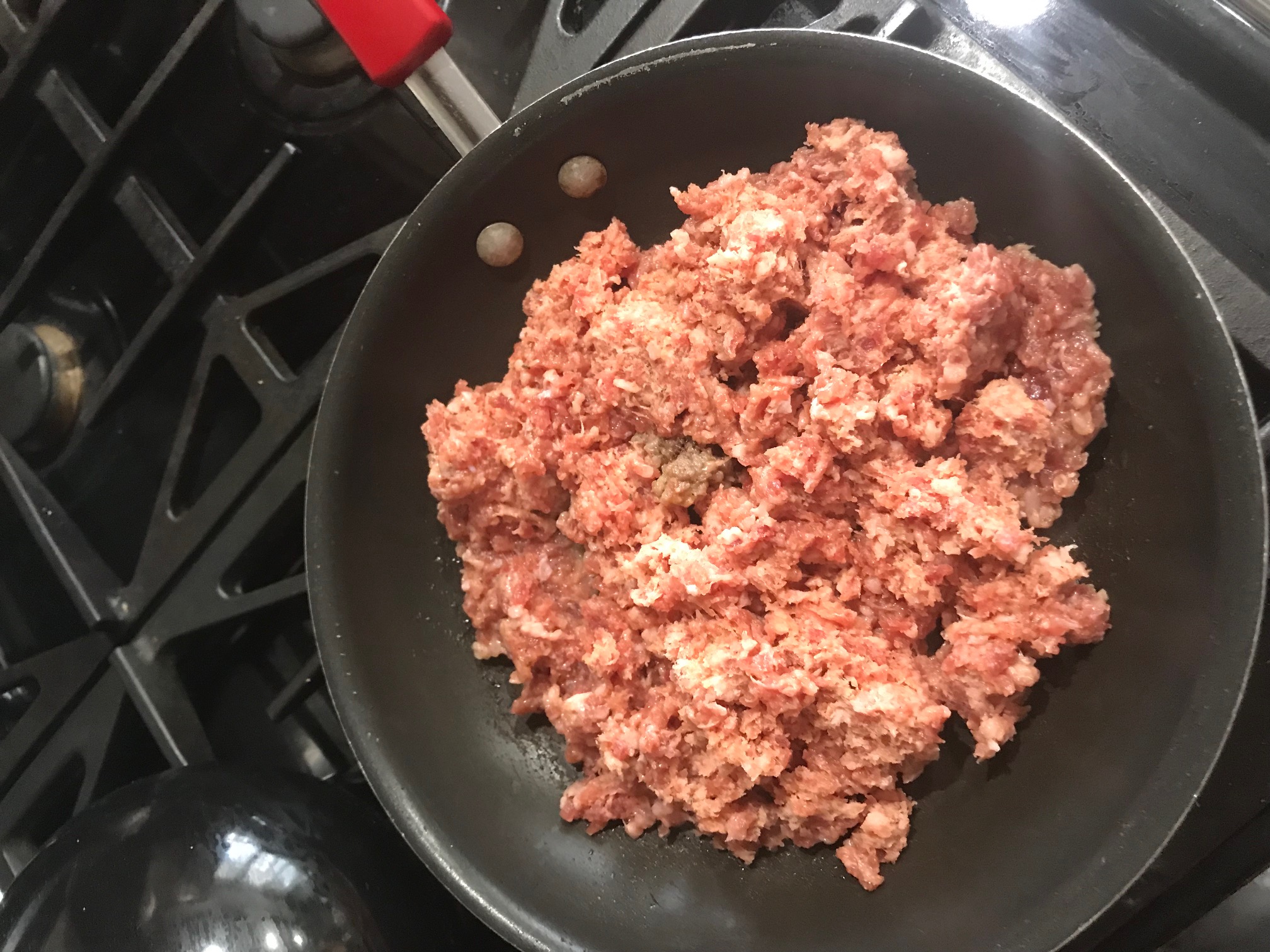 Sausage frying in a frying pan