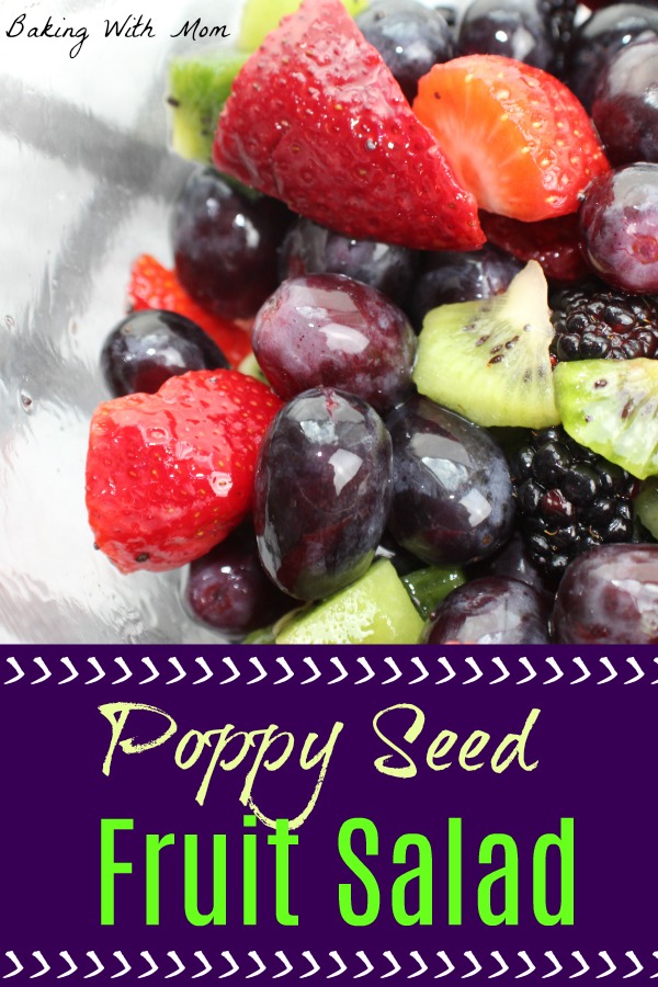 Poppy Seed Fruit Salad in a clear bowl on a towel