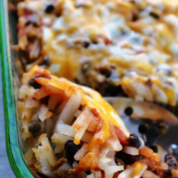 taco casserole in a casserole dish with a spoon.