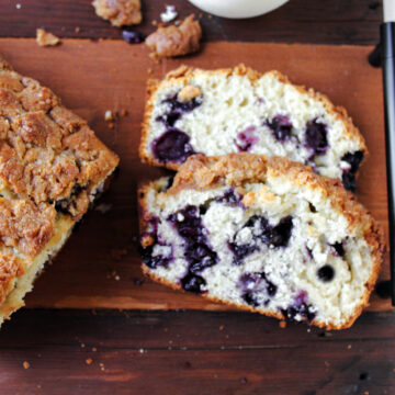 blueberry streusel bread on a wooden cutting board.