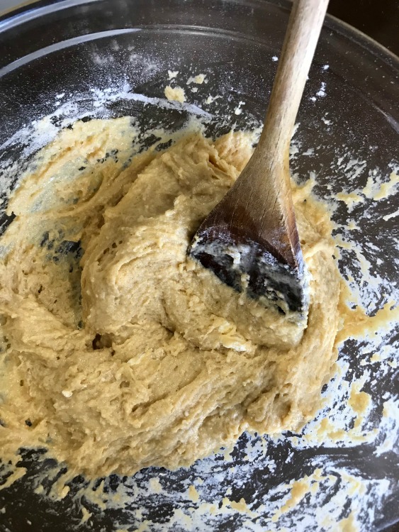 Donut Dough in a clear bowl with a wooden spoon