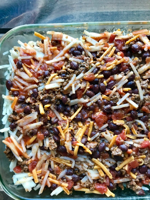 Uncooked taco casserole in a clear baking dish