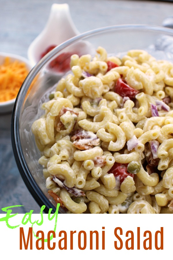 Easy Macaroni Salad in a clear bowl with tomatoes and cheese on the side