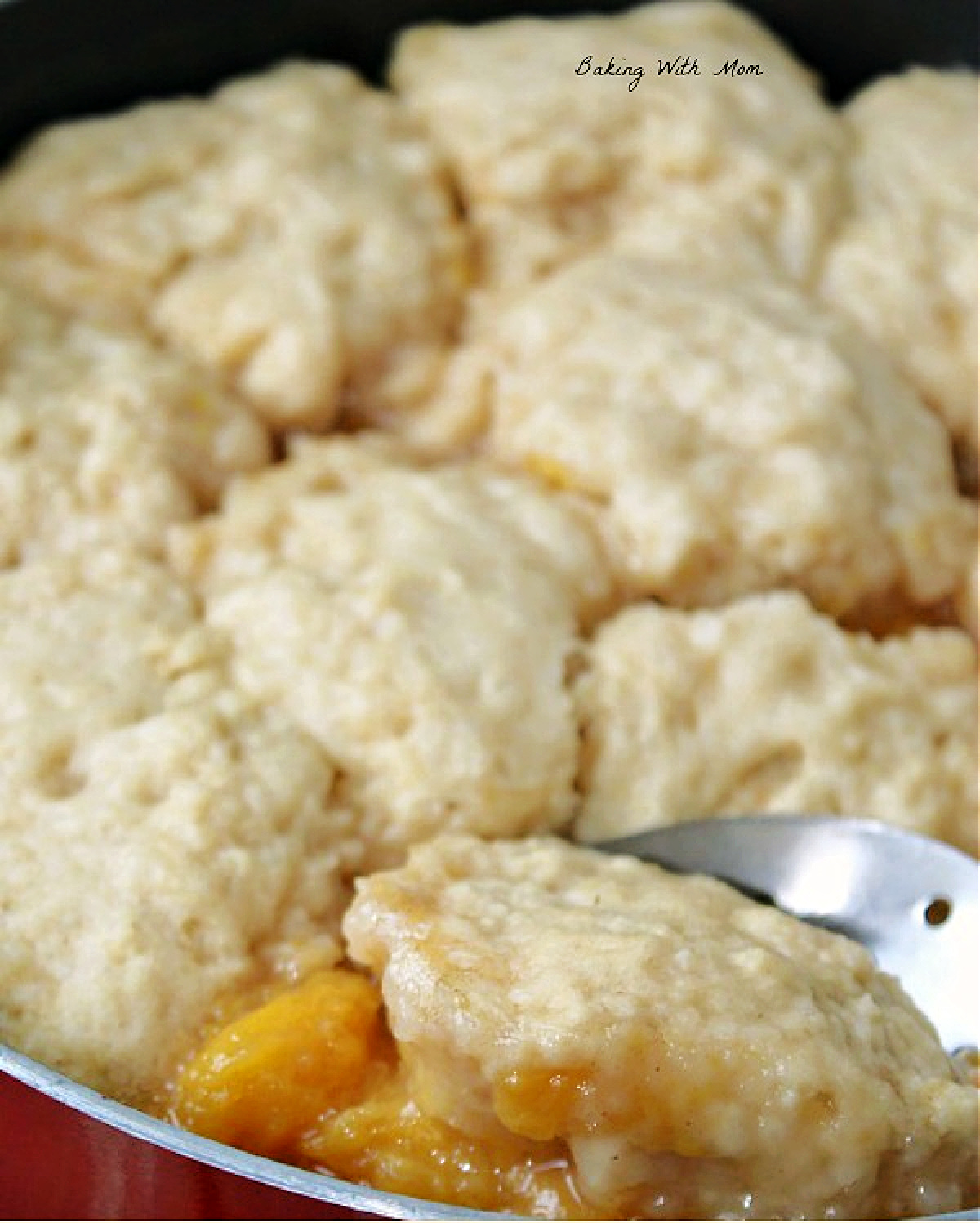 homemade peach dumplings with a spoon.