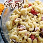 Macaroni Salad in a clear bowl with bacon and onions.