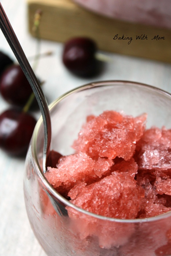 Cranberry shaved ice in a cup with cherry garnish