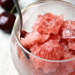 cranberry slush in a cup with a spoon.