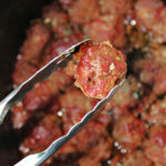BBQ Meatballs with tongs.