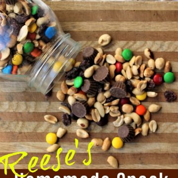 Snack mix with peanuts, m&m's, reese's peanut butter cups on a cutting board