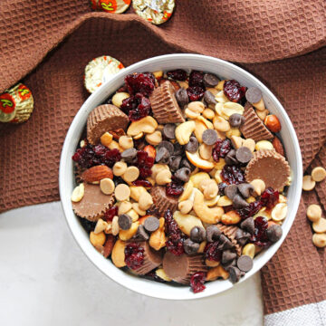 peanuts, peanut butter cups, mixed nuts in a bowl with a brown towel.