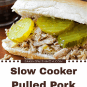 slow cooker pulled pork with a sandwich bun and pickles.