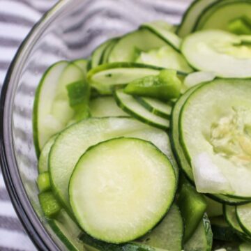 Cucumber Salad in a clear bowl with onions