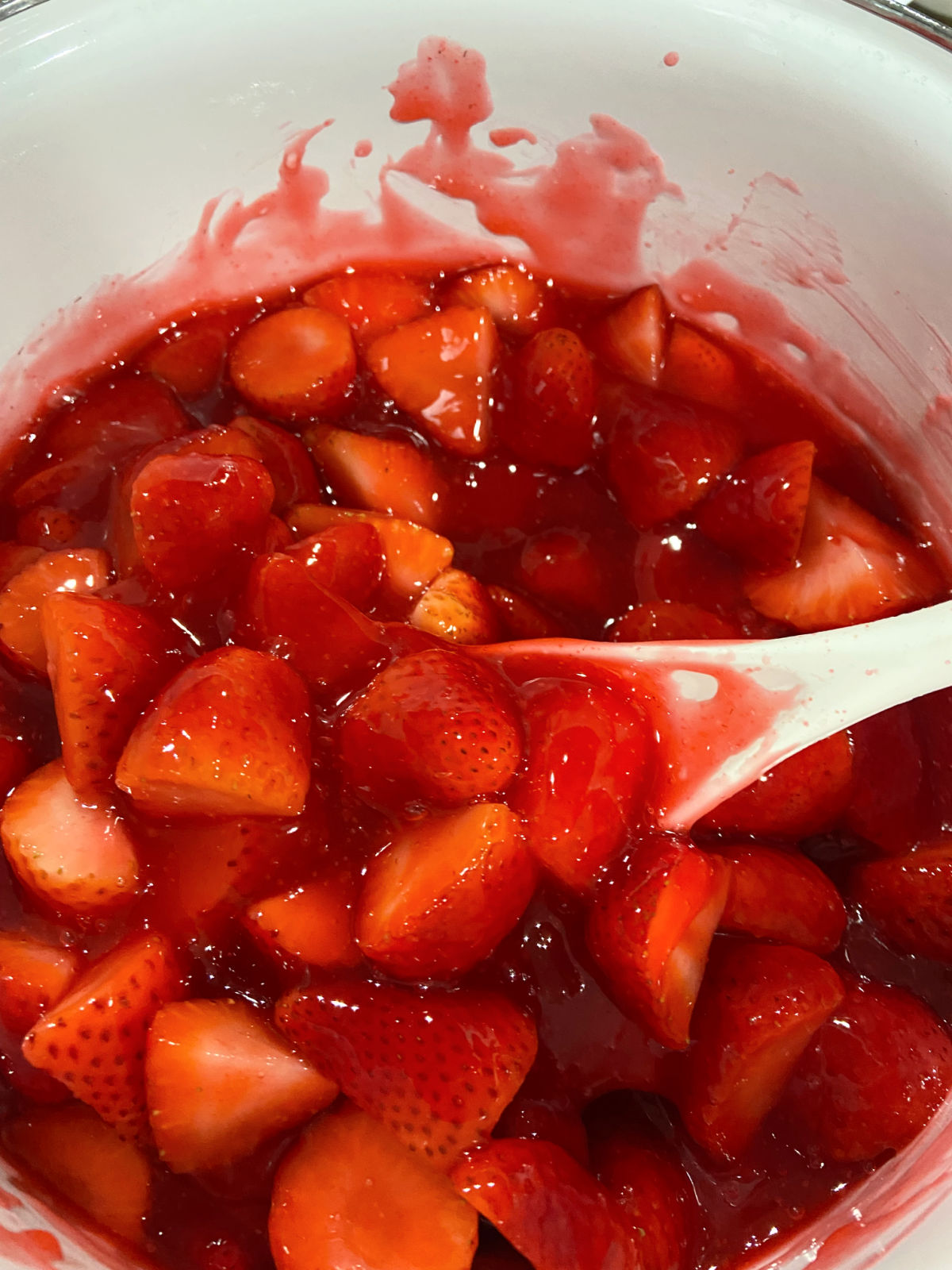 strawberries in red gelatin in a white pan. 