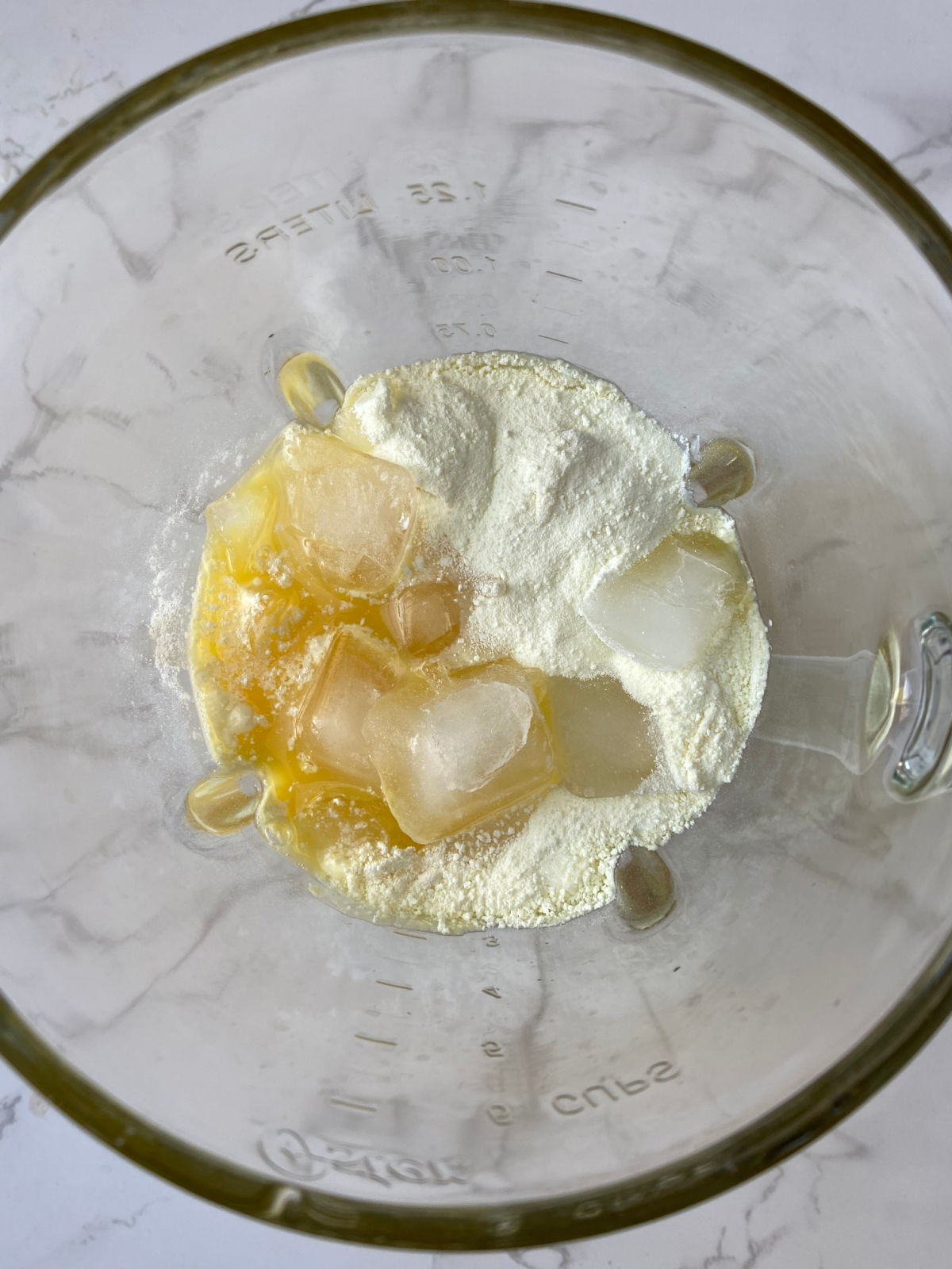 blender with ice and orange juice in it. 