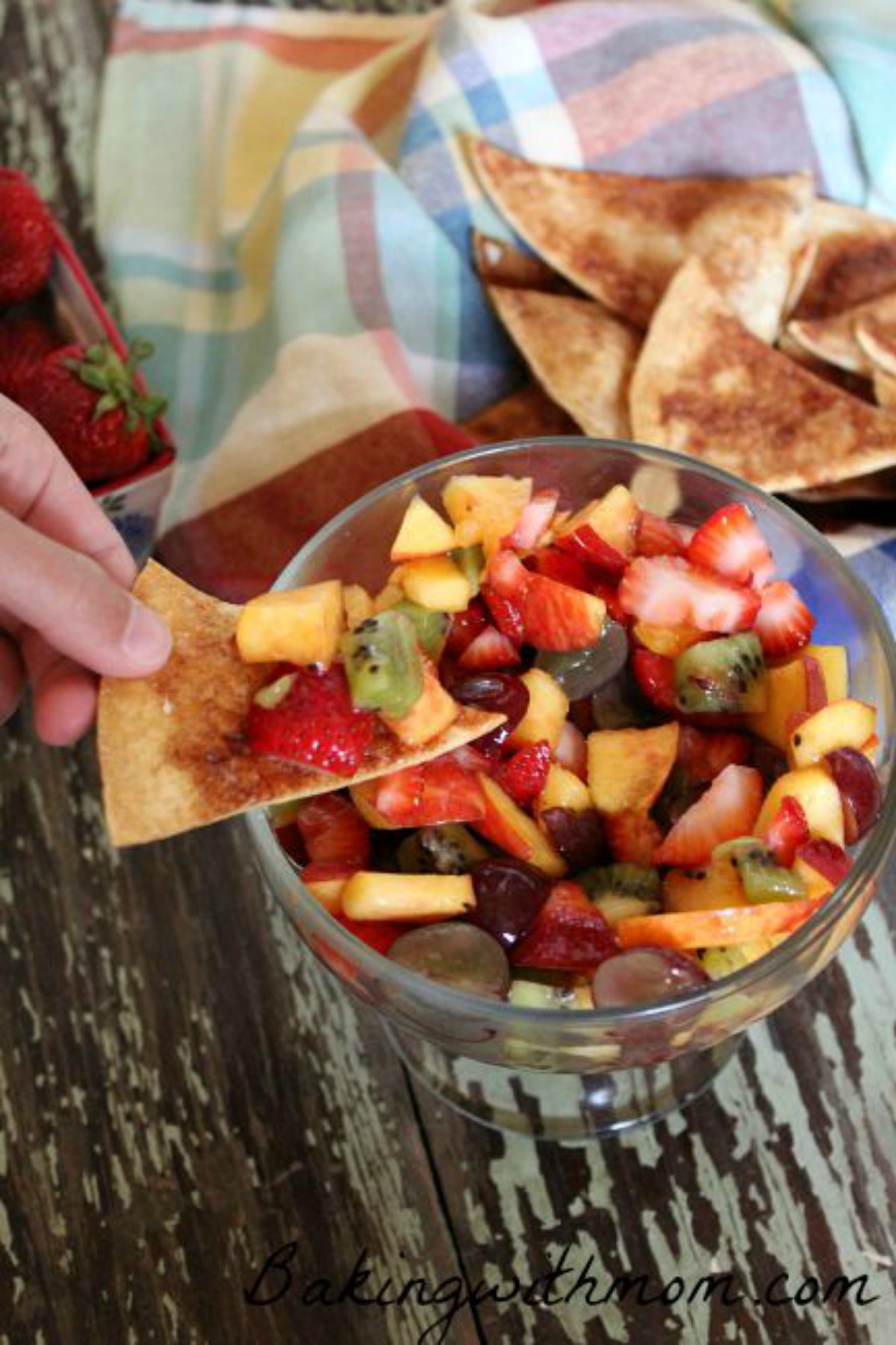 chopped fruit in a clear bowl with cinnamon chips lying in the background