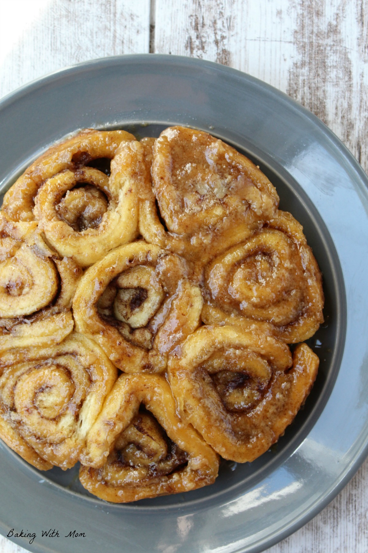 Cinnamon rolls on a gray plate with toppings of brown sugar