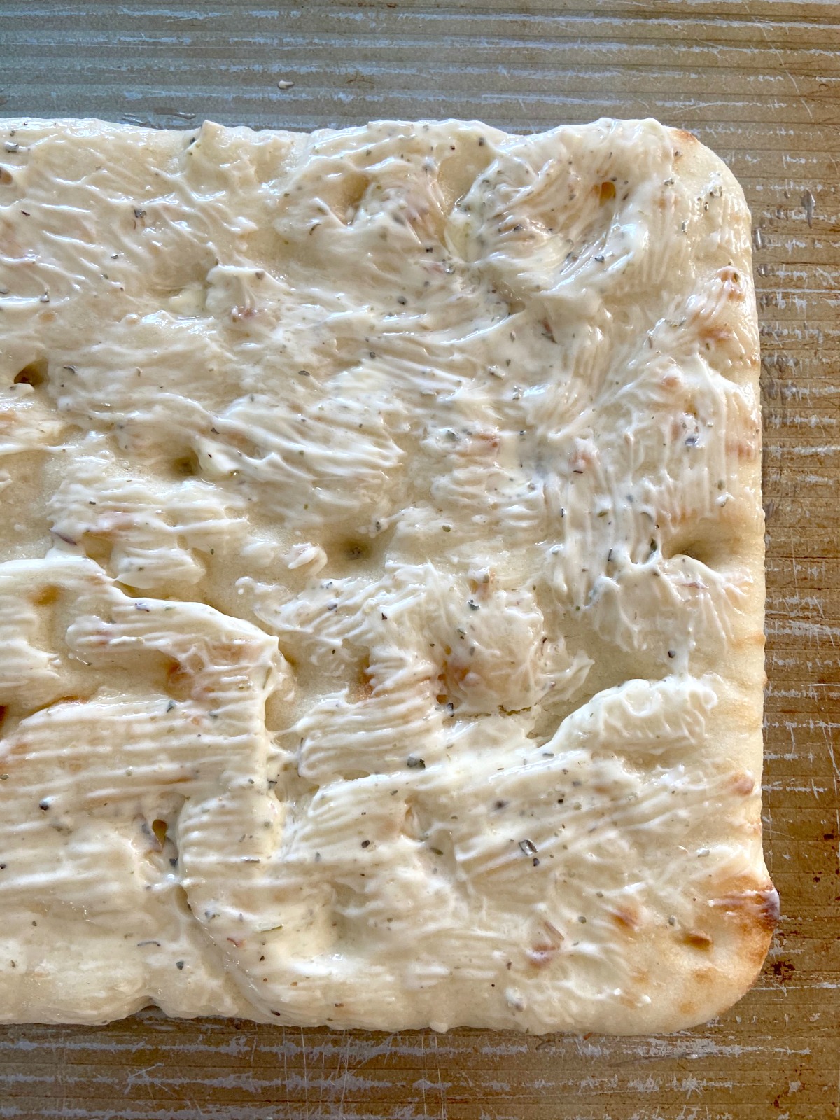 Flatbread covered in a butter spread of garlic and Italian seasoning