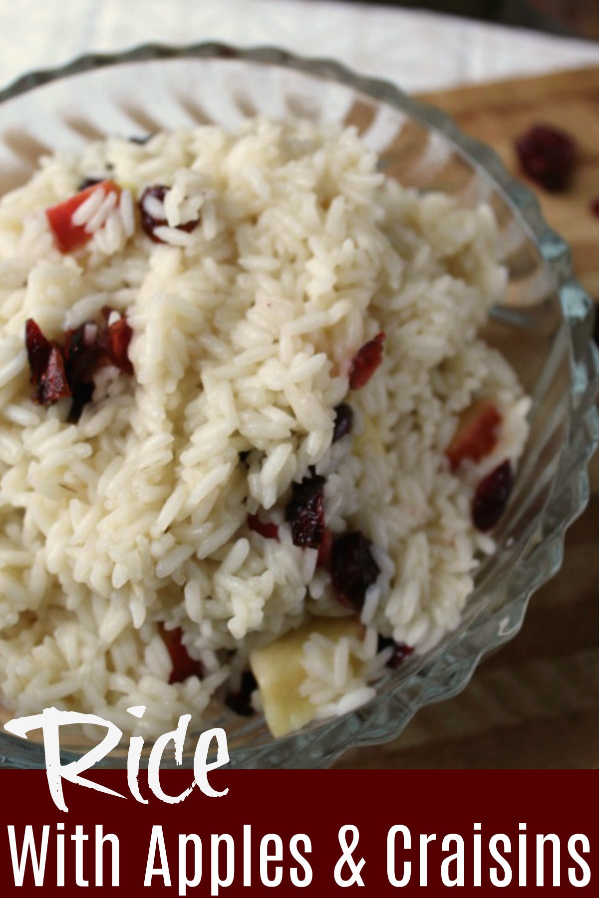 Rice with apples and dried cranberries in a clear bowl with with rice as a base