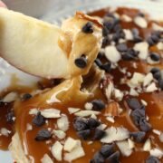 Creamy Caramel Apple Dip with chocolate chips and nuts on top.