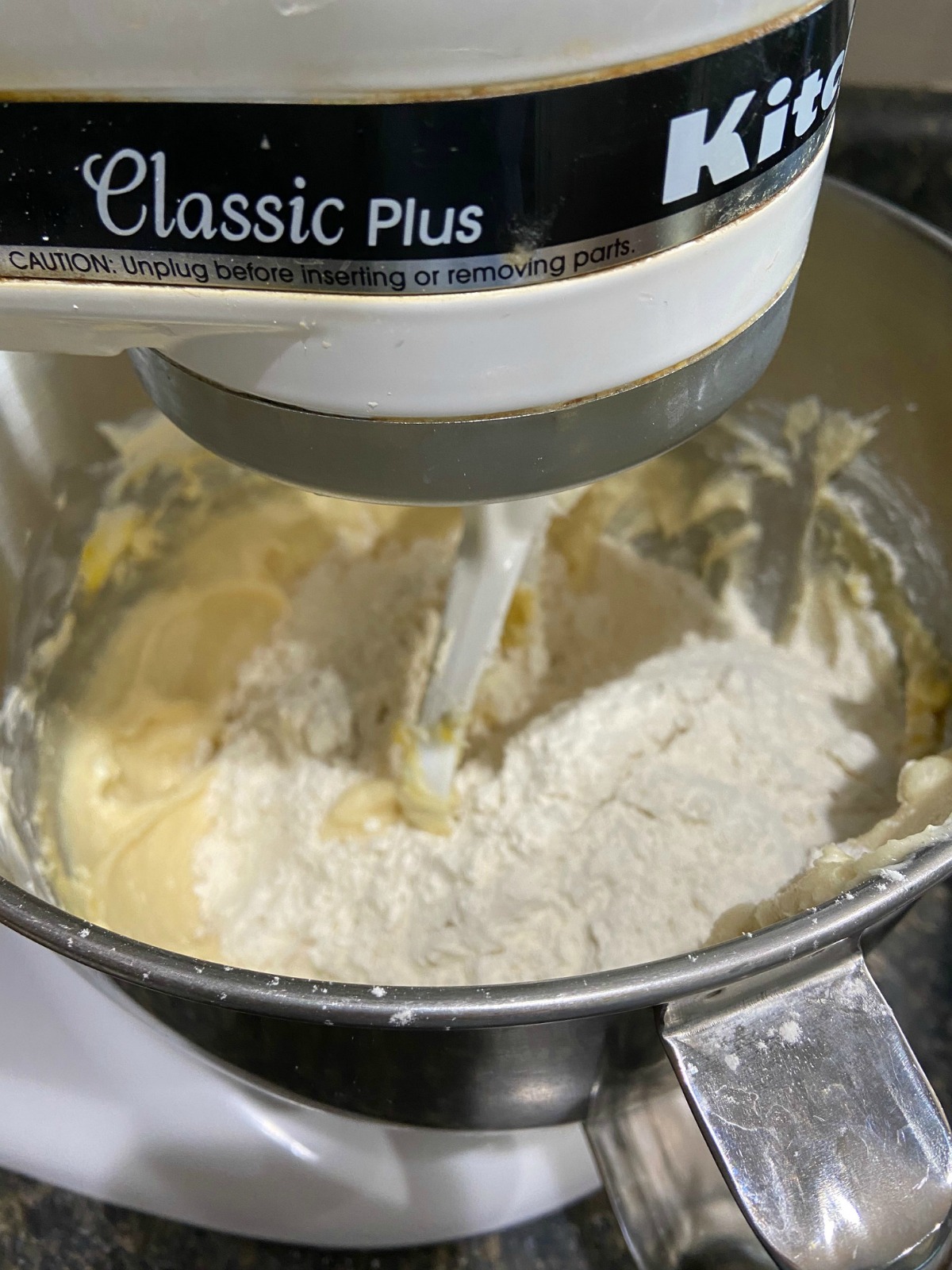 Picture of a stand mixer with cookie dough being mixed. 