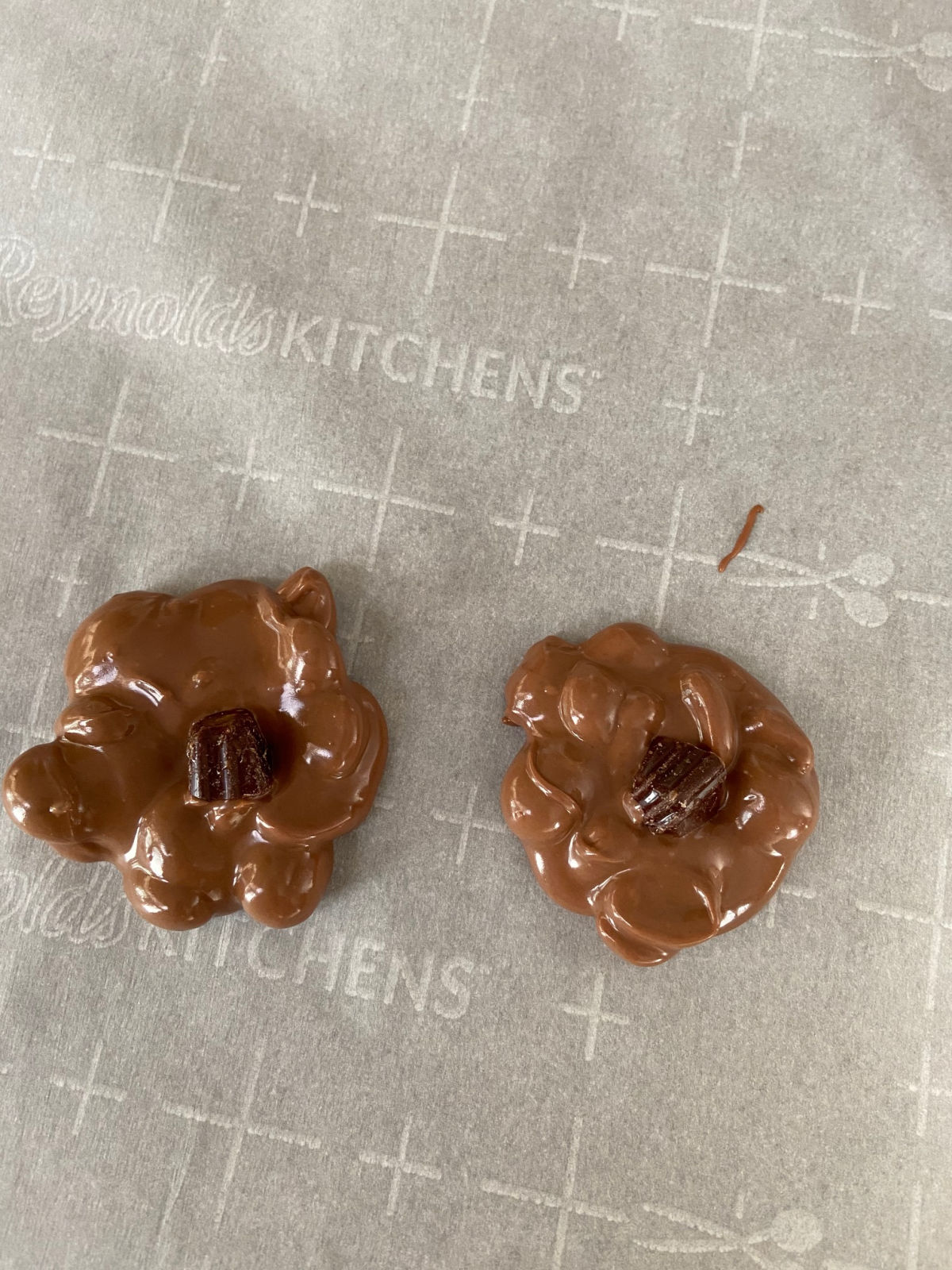 chocolate candy, melted chocolate, on waxed paper with a caramel candy on the inside.