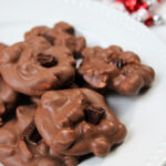 Chocolate candies on a white plate with red and white bells behind