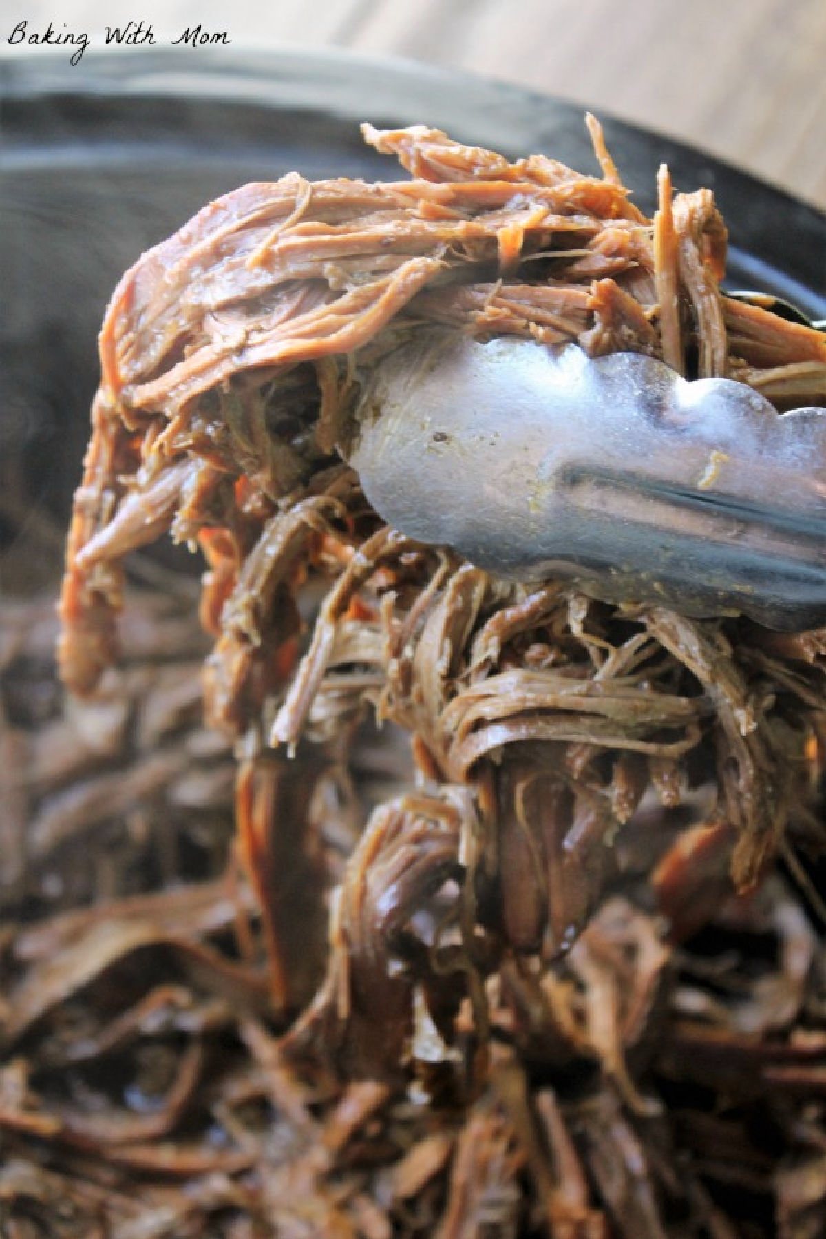 shredded roast beef being held by tongs