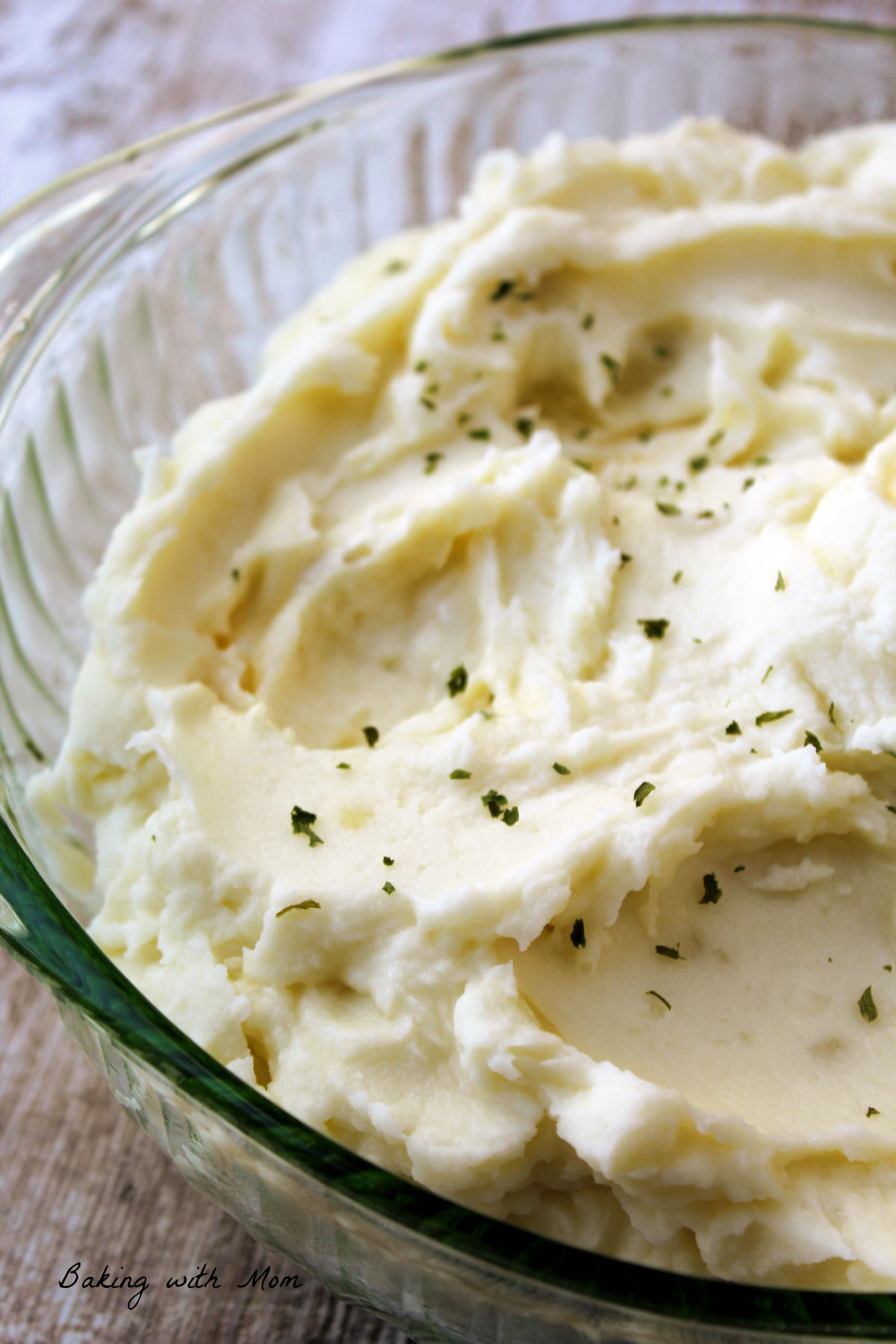 Bowl of mashed potatoes with parsley flakes on top