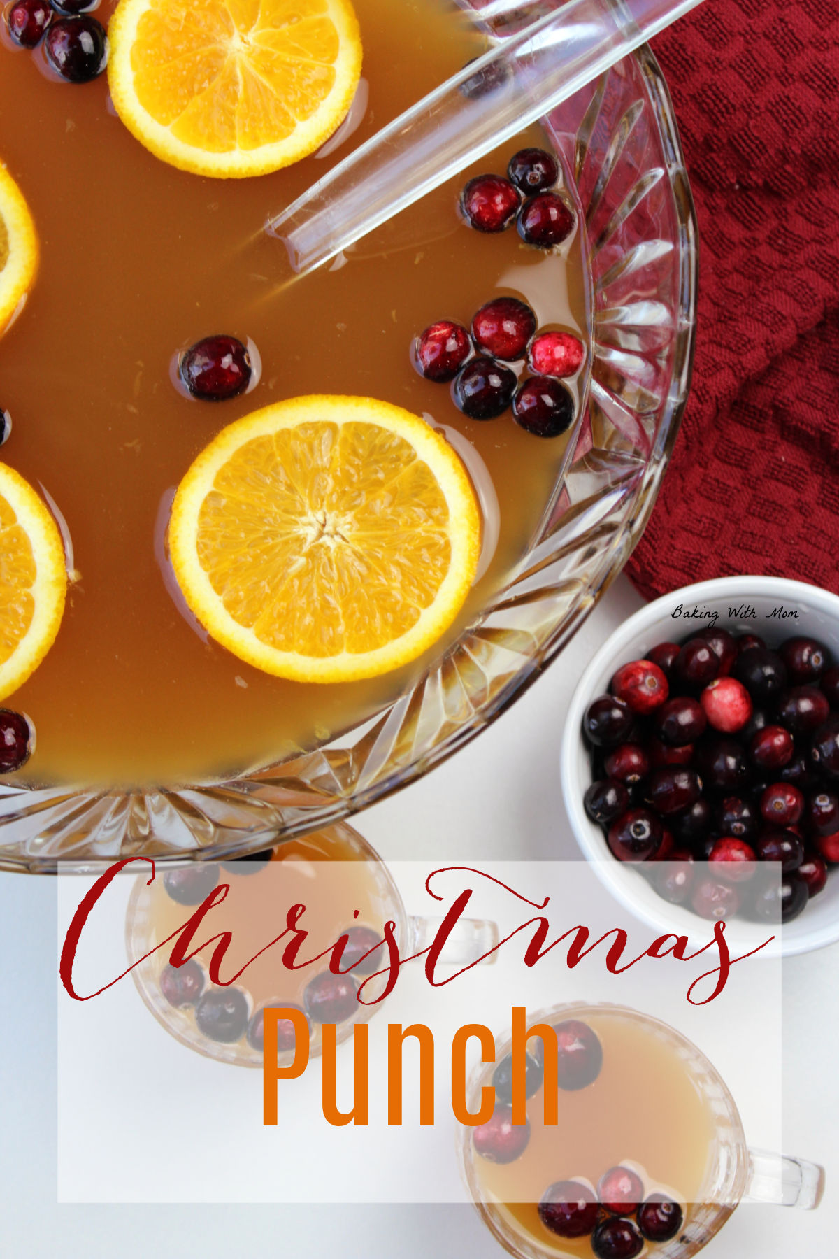 Bowl of punch with oranges and cranberries in a clear bowl with a bowl of cranberries besides. 