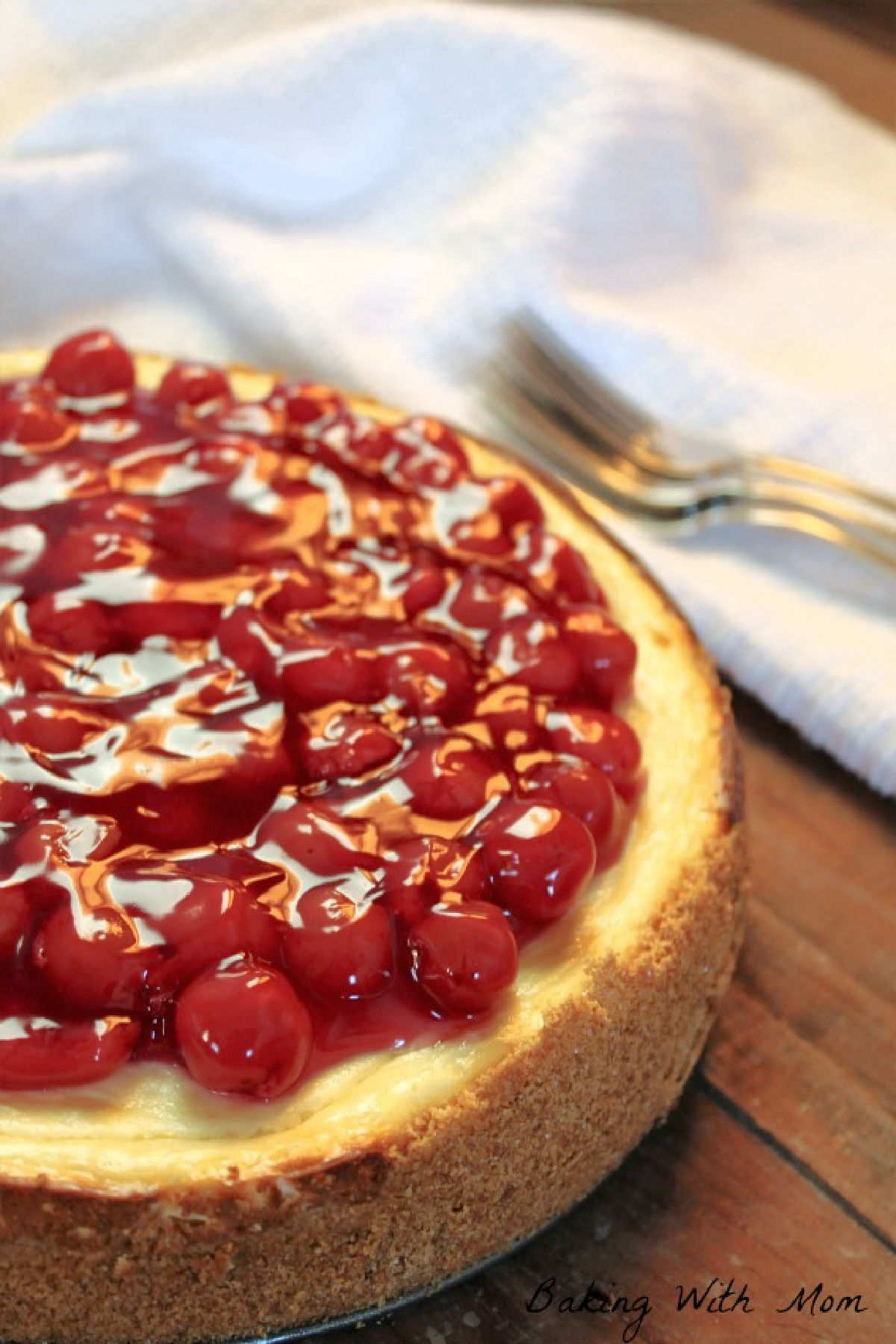 Baked cherry cheesecake on brown boards.