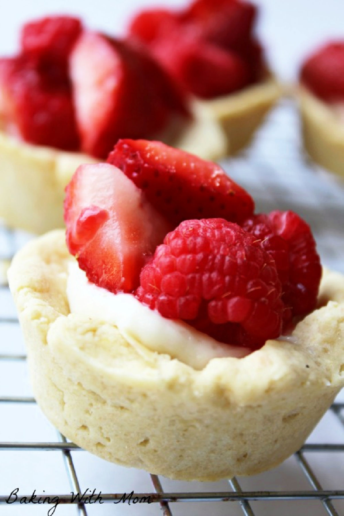 Fresh fruit in a sugar cookie cup with cream cheese on a cooling rack.