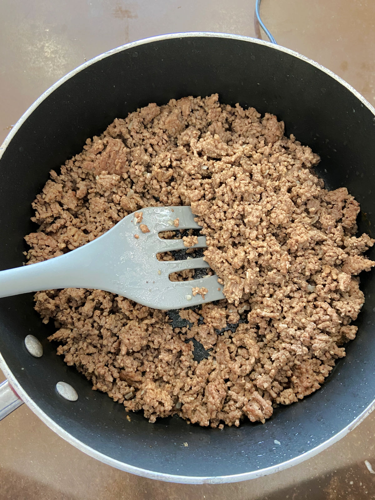 ground beef cooking in a frying pan.