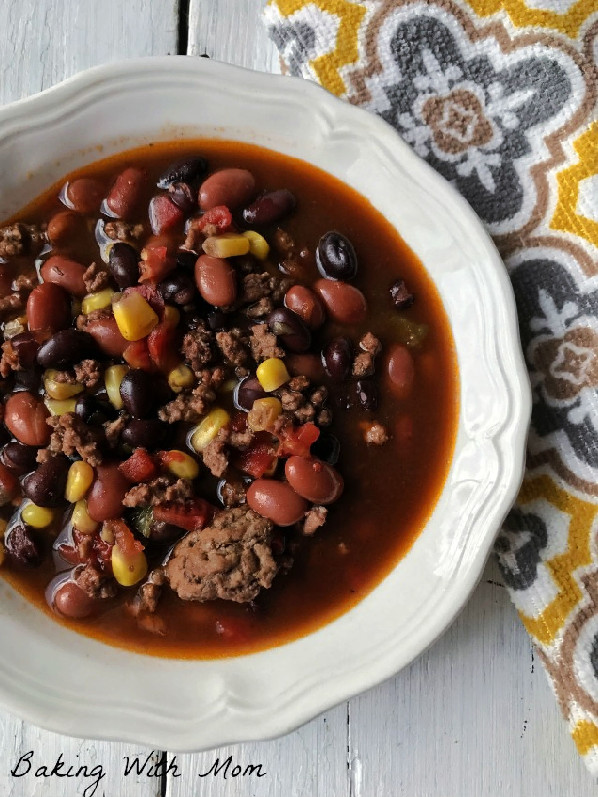 Bowl of taco soup next to a yellow towel. 