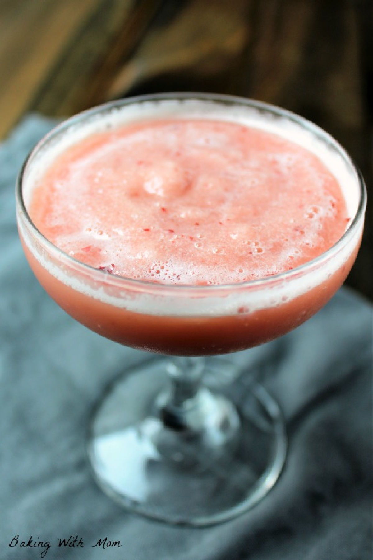 Glass of cherry slush with a gray towel