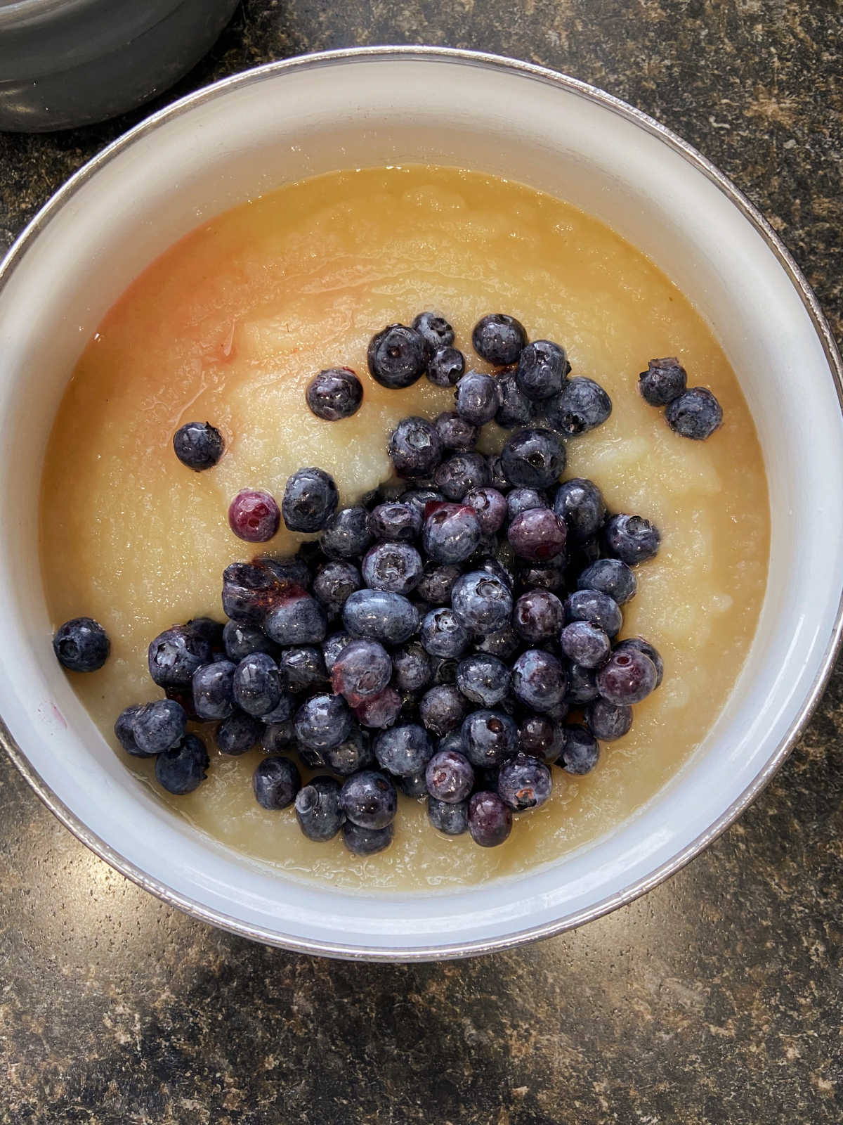 Frozen blueberries in a pan of applesauce.