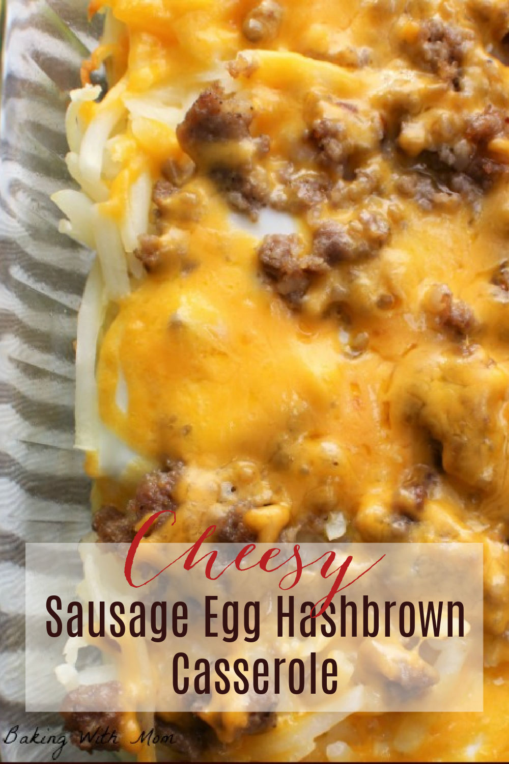 Cheese, hashbrowns and sausage in a clear baking dish. 